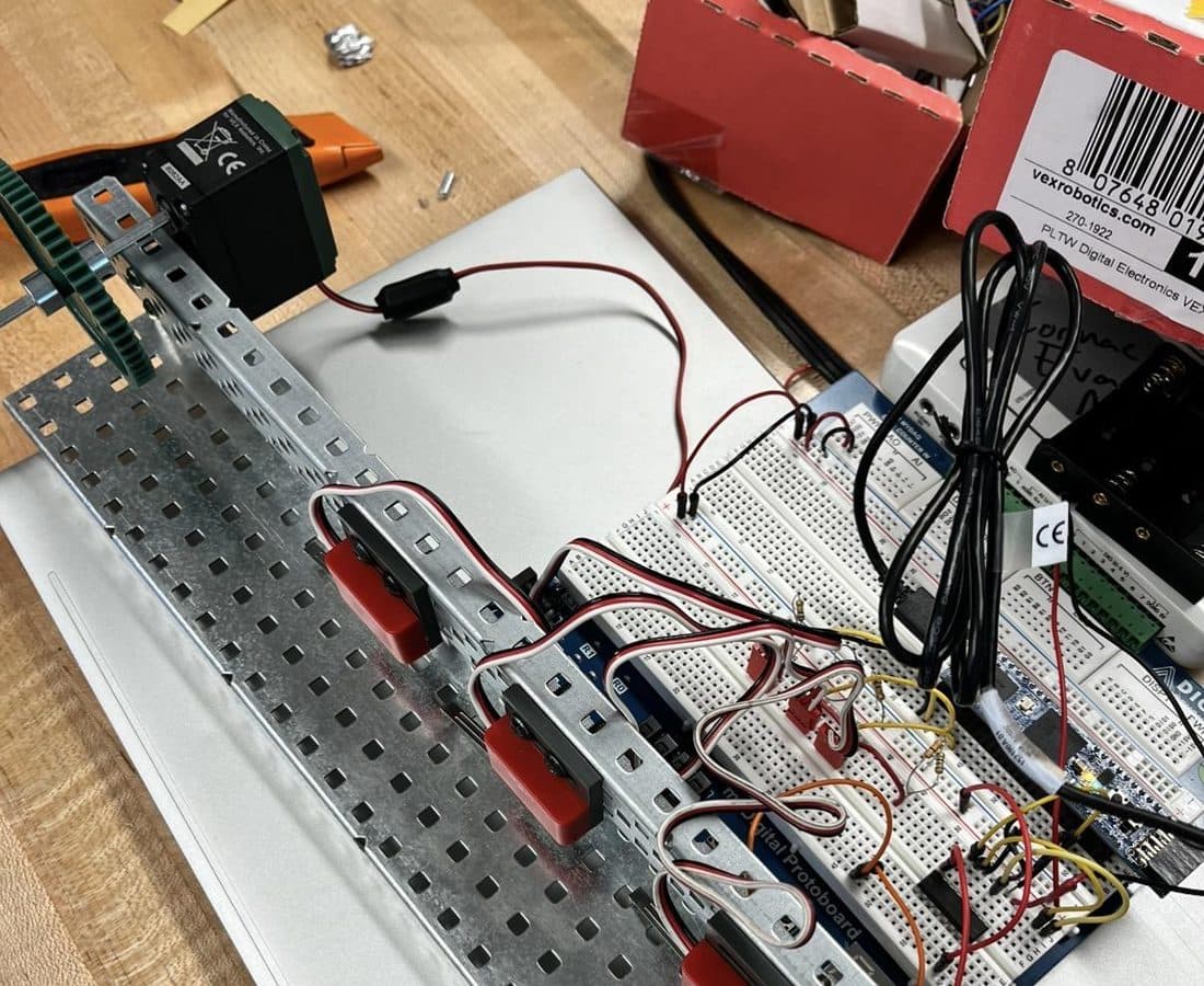 VEX C-channel frame with a breadboard, limit switches, and an Arduino password machine sitting on a laptop.
